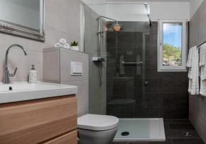 a bathroom with a toilet and a sink and a shower at Casa Katalina in Komiža