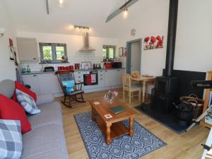 a living room with a couch and a stove at Higher Bumsley Barn in Barnstaple