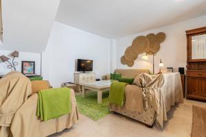 赫雷斯－德拉弗龍特拉的住宿－Casa MNueLa - Centro Jerez - Parking opcional，客厅配有两把椅子和一张桌子