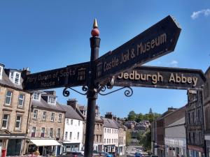 a street sign on a pole in a city at Marys Garden View South in Jedburgh