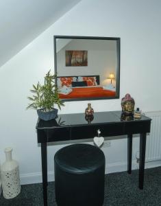 1 dormitorio con escritorio y espejo grande en Marys Garden View South, en Jedburgh