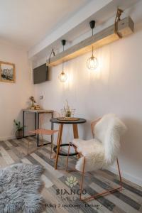 ザコパネにあるWilla Bianco Zakopaneのテーブル、椅子2脚、テーブルが備わる客室です。