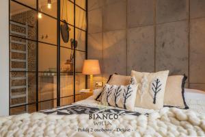 una camera con letto king-size e parete in vetro di Willa Bianco Zakopane a Zakopane