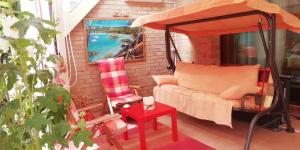 - une terrasse couverte avec une balançoire, un canapé et une table dans l'établissement Chambre plein comfort, à Vimy