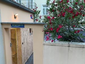 un edificio con una puerta y un arbusto con flores rosas en Opatija Central Studio Apartment, en Opatija