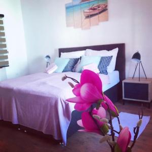 una camera da letto con un letto con un fiore rosa sul pavimento di Krk centar a Krk