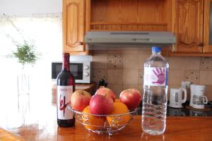 un bol de fruta y una botella de vino en la encimera de la cocina en Capellania, en Tijarafe