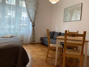 a bedroom with a table and chairs and a couch at Studio in Center in Krakow