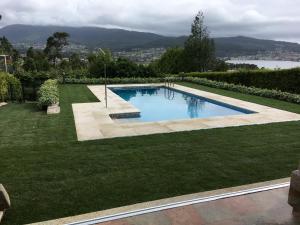 a swimming pool in the middle of a lawn at Playa America! in Nigrán +16 photos