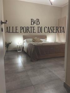 ein Schlafzimmer mit einem Bett mit einem Schild an der Wand in der Unterkunft B&B Alle porte di Caserta in Caserta