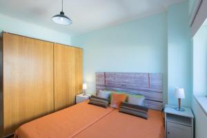um quarto com uma grande cama laranja e 2 cadeiras em Vista Rio em Lisboa