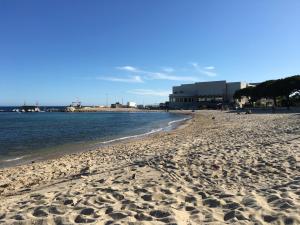 piaszczysta plaża z budynkiem w tle w obiekcie Bandol, vue panoramique sur la mer, la plage, le port w mieście Bandol