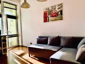 salon z kanapą i czerwoną budką telefoniczną na ścianie w obiekcie Main Square Apartment w Krakowie