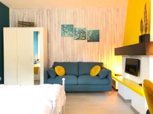 a living room with a blue couch and yellow pillows at CLUA Holiday House in Porto Ceresio