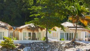 ein Haus mit einer Palme davor in der Unterkunft Sugar Beach, A Viceroy Resort in Soufrière