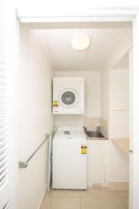 a small kitchen with a refrigerator and a microwave at Noosa Springs Golf & Spa Resort in Noosa Heads