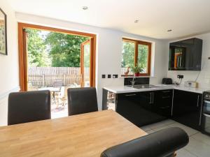a kitchen with a wooden table and black chairs at Meadow View in East Harling
