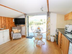 a kitchen with a table and a chair in a room at Lakeside Lodge in East Harling