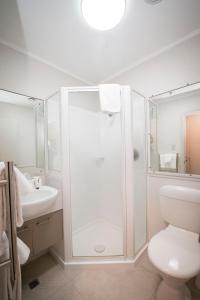 a bathroom with a shower and a toilet and a sink at Quest on Johnston Serviced Apartments in Wellington