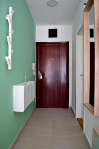uma porta vermelha num corredor com um lavatório em Mateja Apartment em Novi Sad