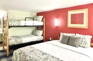 a bedroom with two bunk beds and a red wall at Gatlinburg View Lodge in Gatlinburg