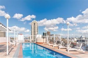 a swimming pool on top of a building with a city skyline at Accommodation Sydney 38 Harbour Street Sydney in Sydney