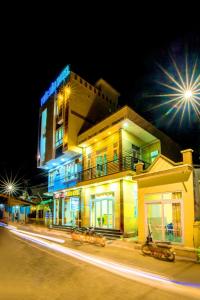 un edificio con luces azules en una calle por la noche en Phuc Hau Hotel - Ly Son, en Ly Son