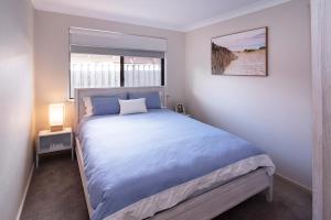 a bedroom with a large bed and a window at GIFFORD HOUSE in Dunsborough