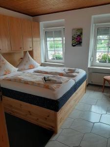 a large bed in a room with two windows at Mosel Panorama in Zell an der Mosel