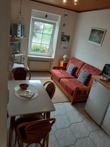 a living room with a red couch and a table at Mosel Panorama in Zell an der Mosel