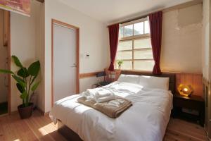 um quarto com uma grande cama branca e uma janela em NIPPONIA HOTEL KOYAsan pilgrimage railway - Vacation STAY 83808 em Kudoyama