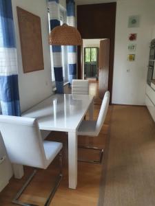 uma sala de jantar com uma mesa branca e cadeiras em Appartment Weingut Hess em Neusiedl am See