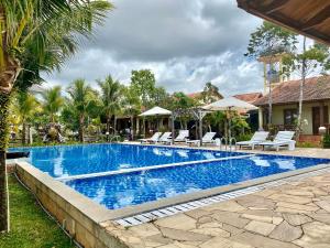 a pool with chairs and umbrellas next to a house at Villa Lien Tho in Phú Quốc