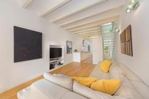 a living room with a white couch and a tv at Catany - Casa familiar in Palma de Mallorca