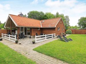 a small house with a white fence in the yard at 5 person holiday home in Middelfart in Middelfart