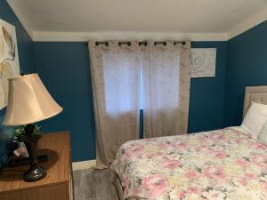 een slaapkamer met een bed, een lamp en een raam bij Baby Blue Sky - Price 2bd - Newly remodeled - nearby trails in Price