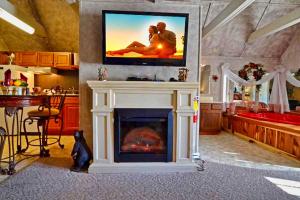a living room with a fireplace with a tv above it at Mountain Serenity in Gatlinburg
