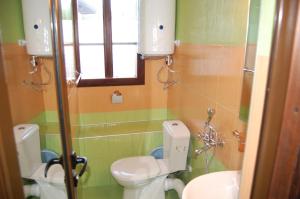 a bathroom with two toilets and a sink and a window at Kazasovata Guest House in Tryavna