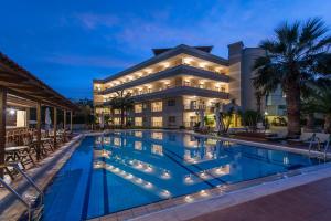 a hotel with a swimming pool in front of a building at Mirtilos Studios & Apartments in Kissamos