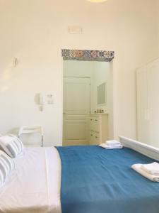 1 dormitorio con 1 cama grande con manta azul en Le Fiche d’India, en Giuggianello