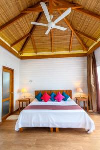 a bedroom with a bed with a ceiling fan at White Sands Beach Resort Lembeh in Bitung