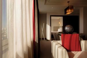 ロンドンにあるプルマン ロンドン セントパンクラスのソファ付きの部屋、窓、ベッドルーム1室が備わる客室です。