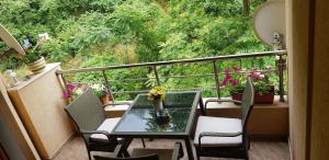 a balcony with a table and chairs and flowers on it at Апартамент Мегилукс in Blagoevgrad