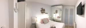 ein weißes Schlafzimmer mit einem Bett und einem Spiegel in der Unterkunft Home Sweet Home Main St Pamplona in Pamplona
