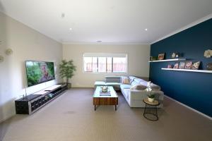sala de estar con sofá y TV de pantalla plana en 6 Bedrooms Contemporary Big House at Pakenhem, en Pakenham