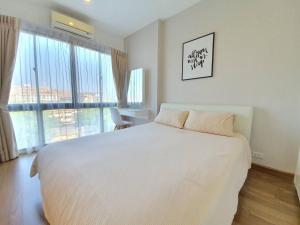 チェンマイにあるModern loft room& Rooftop pool at Nimman 603NMの白いベッドと大きな窓のある寝室 +8枚の写真