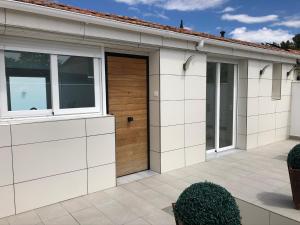 garaje blanco con puerta y ventanas de madera en Casa en CARABAÑA a 30 minutos de MADRID, en Carabaña