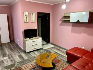 een woonkamer met een bank en een tv bij Modena rooms center of Stara Zagora in Stara Zagora