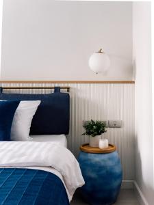 a bedroom with a blue bed and a potted plant at Blu 395 in Bangkok