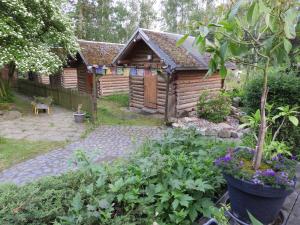 a garden with a wooden cabin in the background at Birkenhof Ashram Familien Blockhütten in Hartau